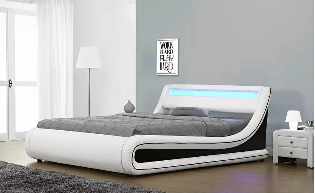 Moderan bračni krevet s podnicom i prostorom za odlaganje u kombinaciji crno-bijele eko-kože. RGB LED rasvjeta pridonosi ravnoteži prostora.